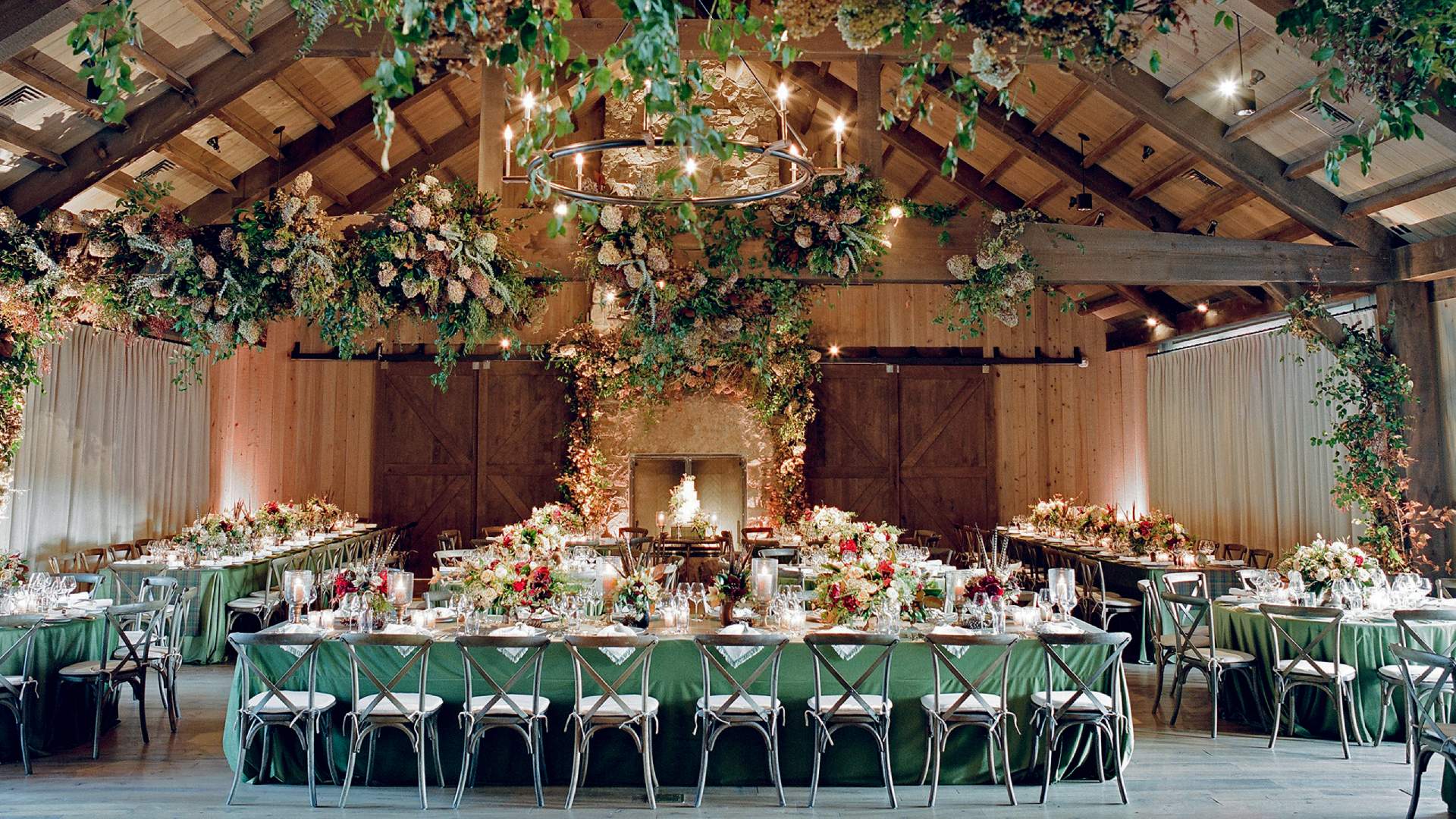 A large table with chairs and flowers hanging from the ceiling.